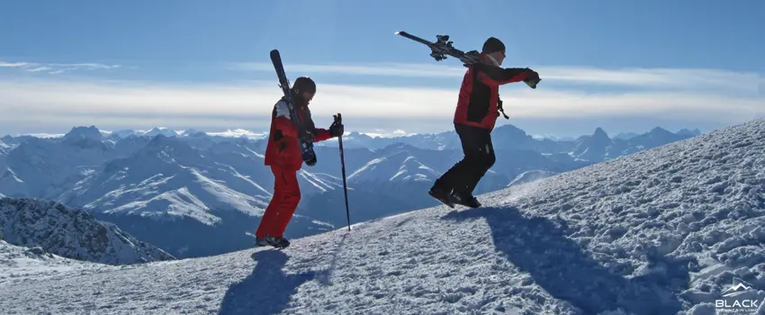Skiers climb on a snowy mountain slope.