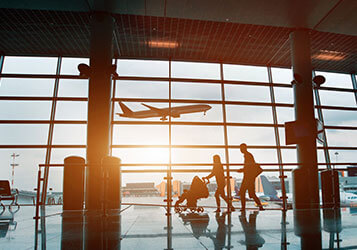 Airport, silhouette of young family with baby traveling by plane.